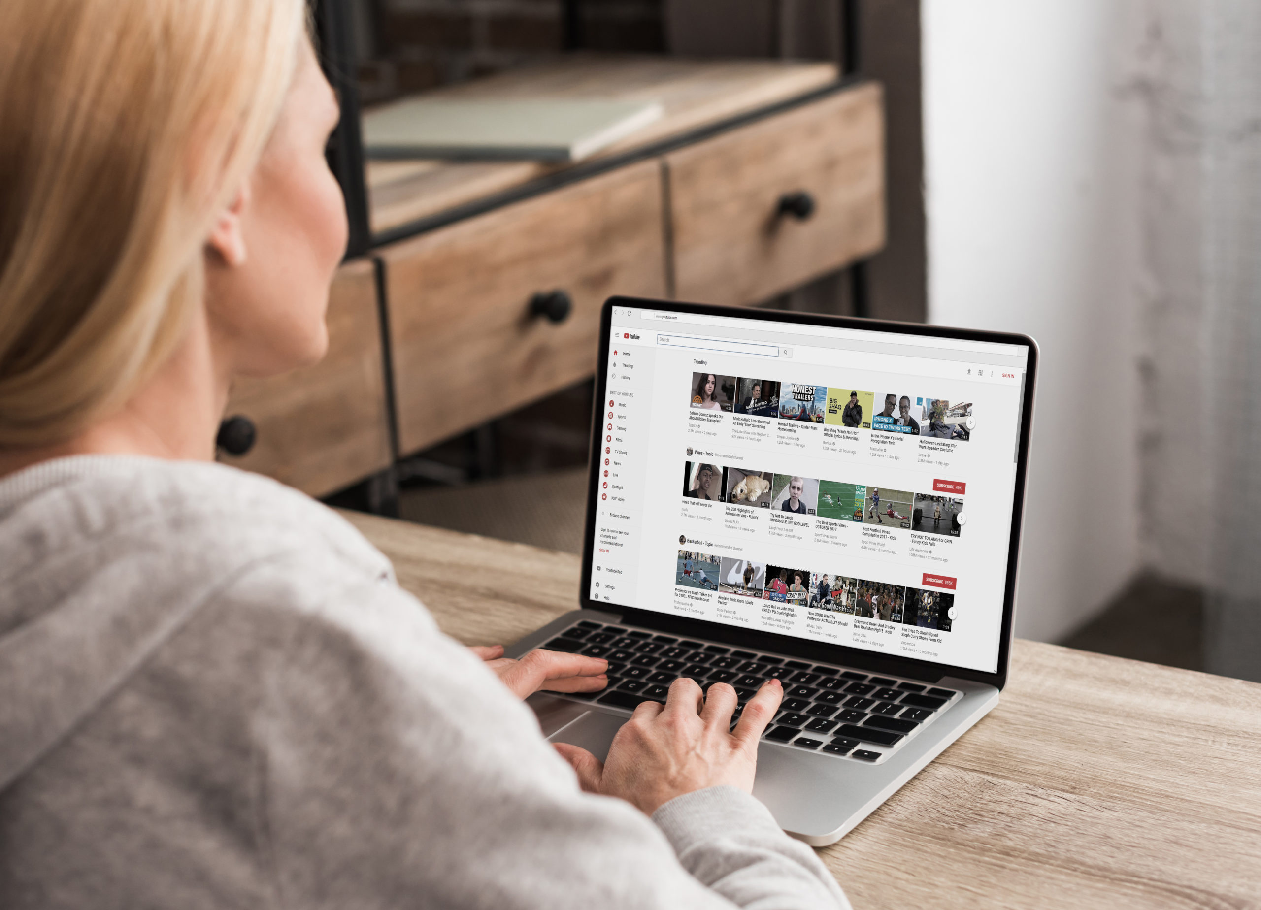 woman using laptop with youtube on screen