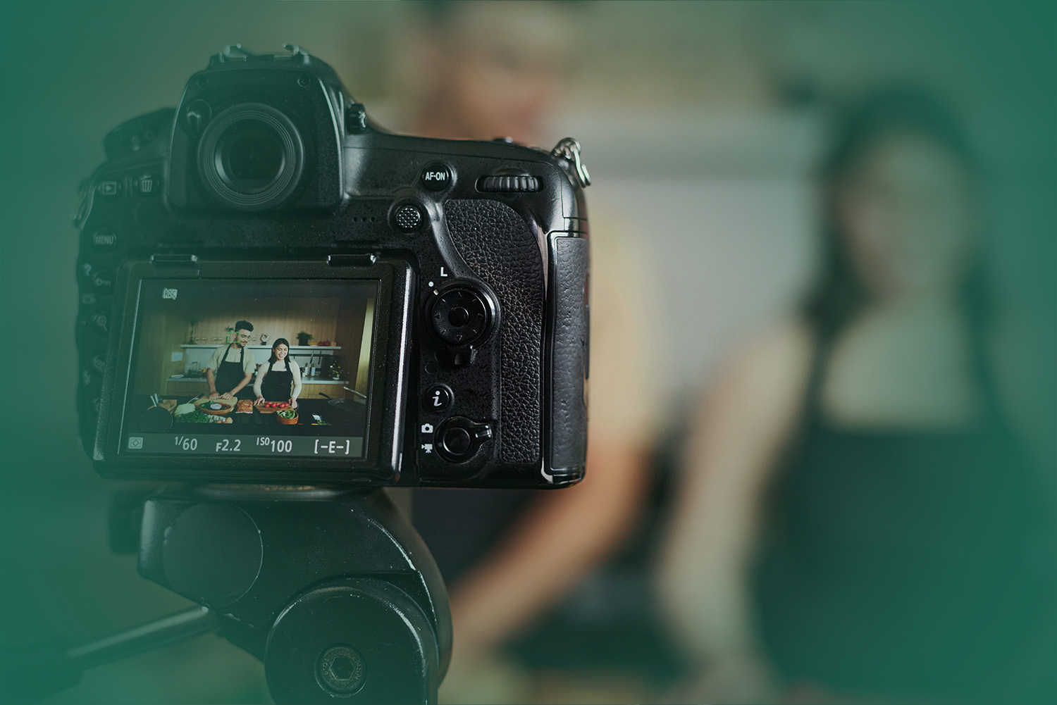 closeup shot of professional digital camera recording man and woman standing by kitchen counter