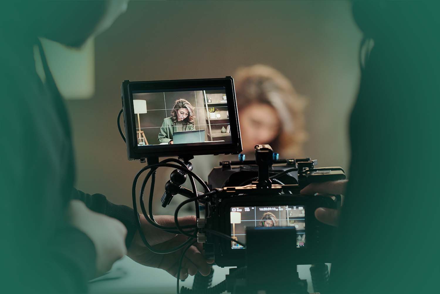 close-up of steadicam screens with model using laptop by table