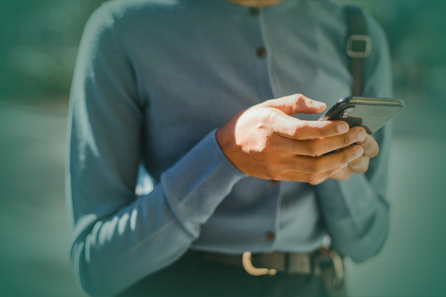 close-up photograph of a person’s hands using a cell phone